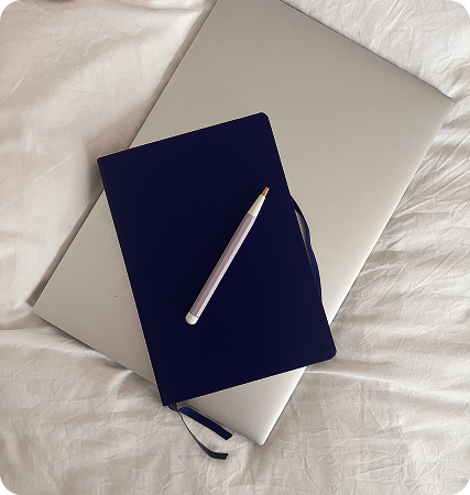 Booknote et Macbook posé sur un lit